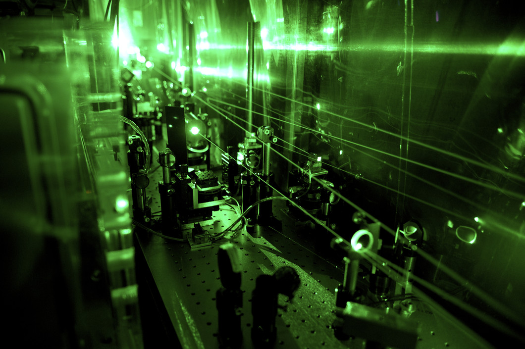 Vue d'une partie du système complexe de lasers nécessaire pour l'expérience de la détermination du rayon du proton. A cet endroit, la lumière invisible du laser infrarouge est convertie en un laser de lumière verte. (PSI/A. Antognini und F. Reiser)