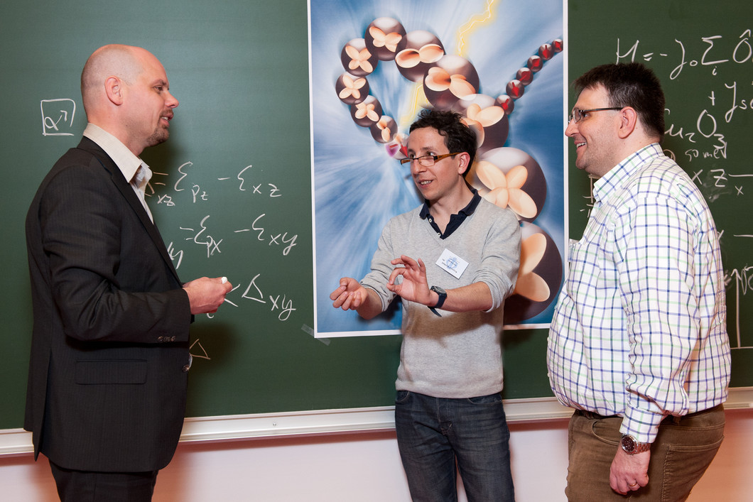 Jeroen van den Brink (links) und Krzysztof Wohlfeld (mitte) vom IFW Dresden diskutieren die theoretische Beschreibung der Messresultate mit PSI-Forscher Thorsten Schmitt (rechts). (Foto: Philip Dera)