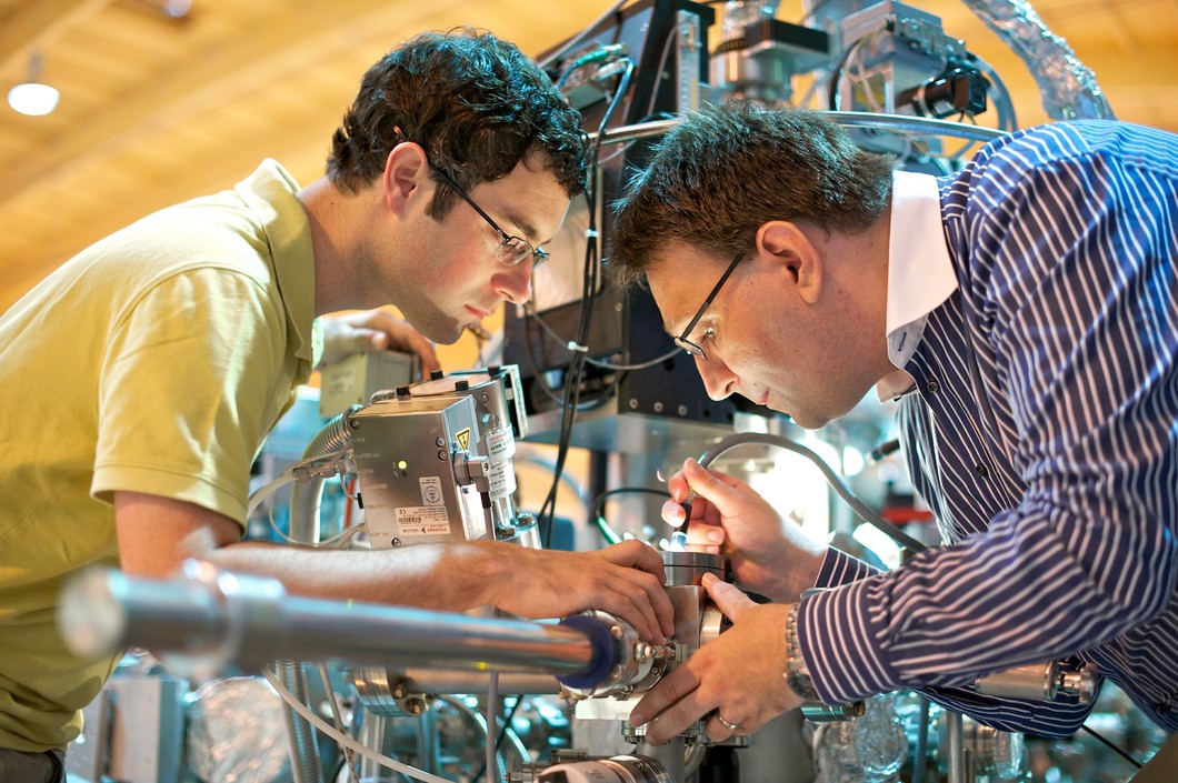 Les chercheurs Mark Dean (Brookhaven National Laboratory) et Thorsten Schmitt (Institut Paul Scherrer) au poste de mesure ADRESS à la source de lumière synchrotron suisse. Photo : PSI/M. Fischer