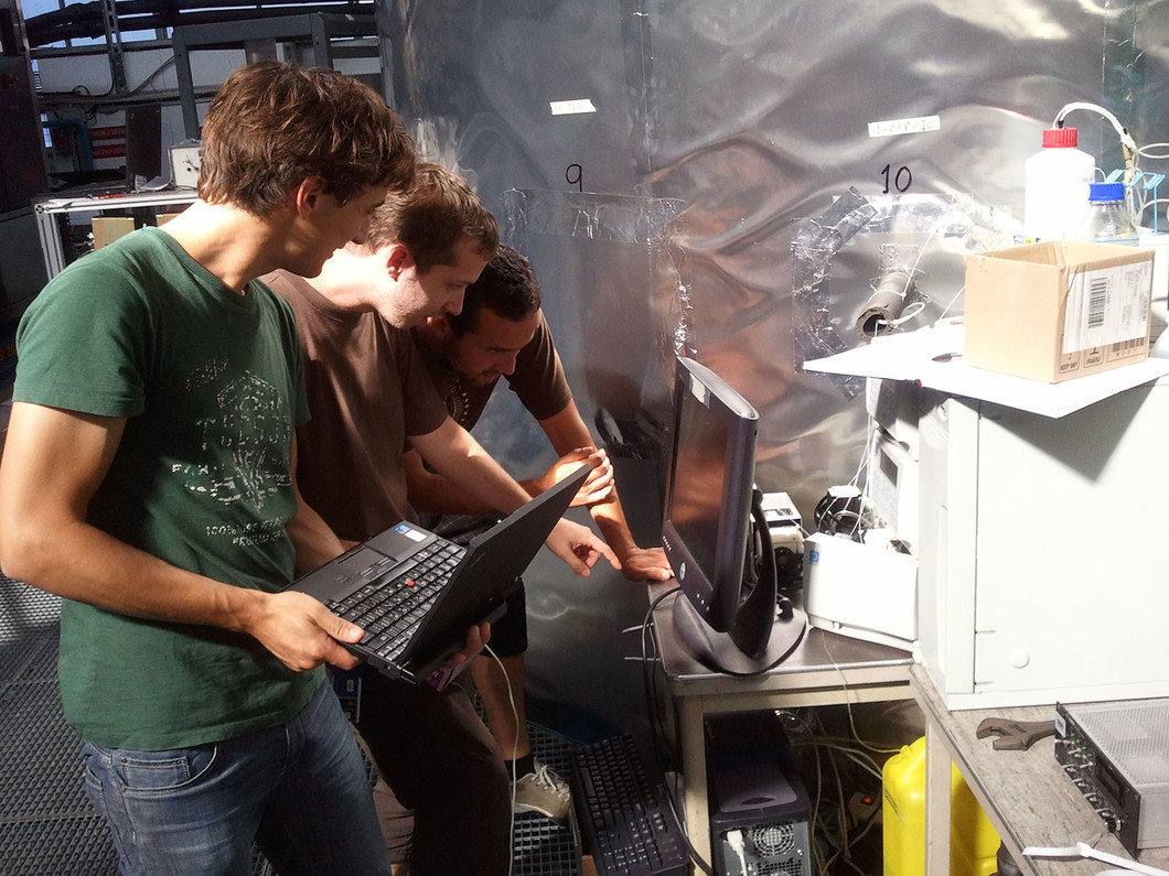 Francesco Riccobono, Arnauld Praplan und Frederico Bianchi, Doktoranden am Labor für Atmosphärenchemie des PSI, kontrollieren die Resultate  der Amin-Messung zum CLOUD-Experiments auf dem Bildschirm. (Bild: CERN)