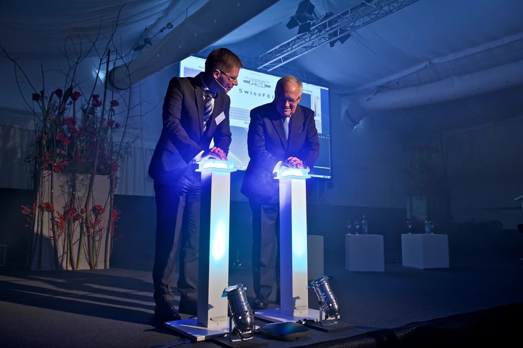 Johann Schneider-Ammann, président de la Confédération, et Joël Mesot, directeur du PSI, en train d’appuyer sur le bouton rouge. (Photo: Institut Paul Scherrer/Markus Fischer)