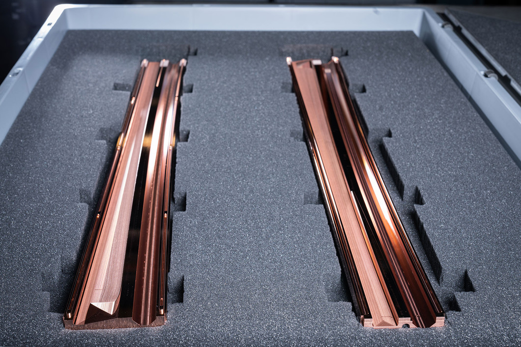 Two two half-shells made of copper are lying ready in a foam box