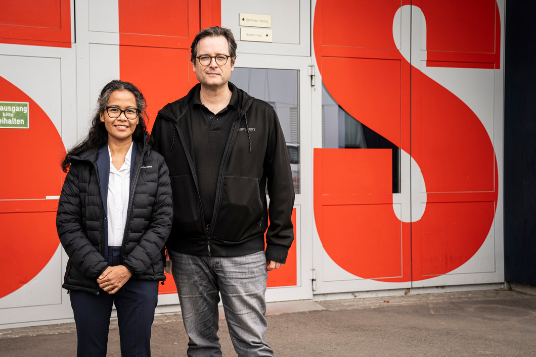 Margie Olbinado und David Mannes vor dem Eingang zur Synchrotron Lichtquelle Schweiz SLS, in der die Untersuchungen mit Synchrotronlicht durchgeführt wurden. In unmittelbarer Nachbarschaft dazu liegt auf dem Gelände des PSI die Schweizer Spallations-Neutronenquelle SINQ, die Neutronen für weitere Analysen liefert.