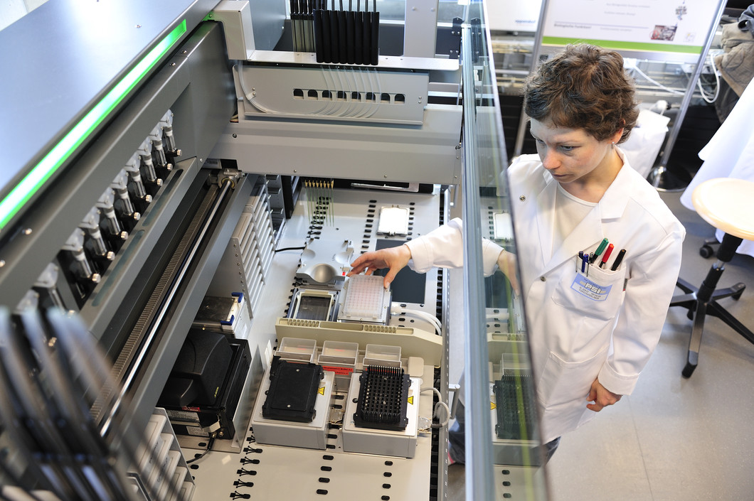 Die Strukturbiologin Natacha Olieric neben dem Roboter, an dem am PSI das automatisierte Verfahren zur Herstellung von Multiprotein-Komplexen implementiert worden ist. (Foto: PSI / F. Reiser)