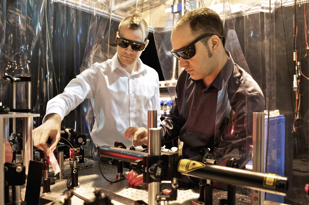 PSI scientists Loïc Le Guyader (left) and Souliman El Moussaoui adjusting the laser that was used to heat the magnetic sample. (Paul Scherrer Institute/M. Fischer)