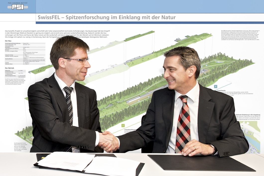 Joël Mesot, Direktor des PSI, und Peter Limacher, CEO ALPIQ InTec AG, bei der Unterzeichnung des Totalunternehmer-Werkvertrags.