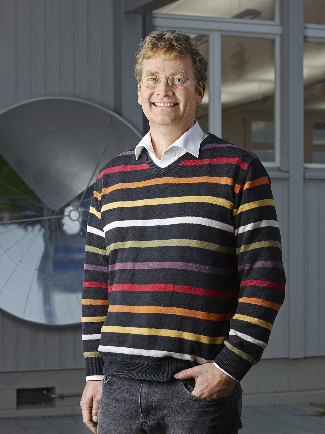 Beat Henrich, Head of the PSI lab school iLab, in front of a parabolic dish, which is used to demonstrate sound transmission over large distances. (Photo: Scanderbeg Sauer Photography)