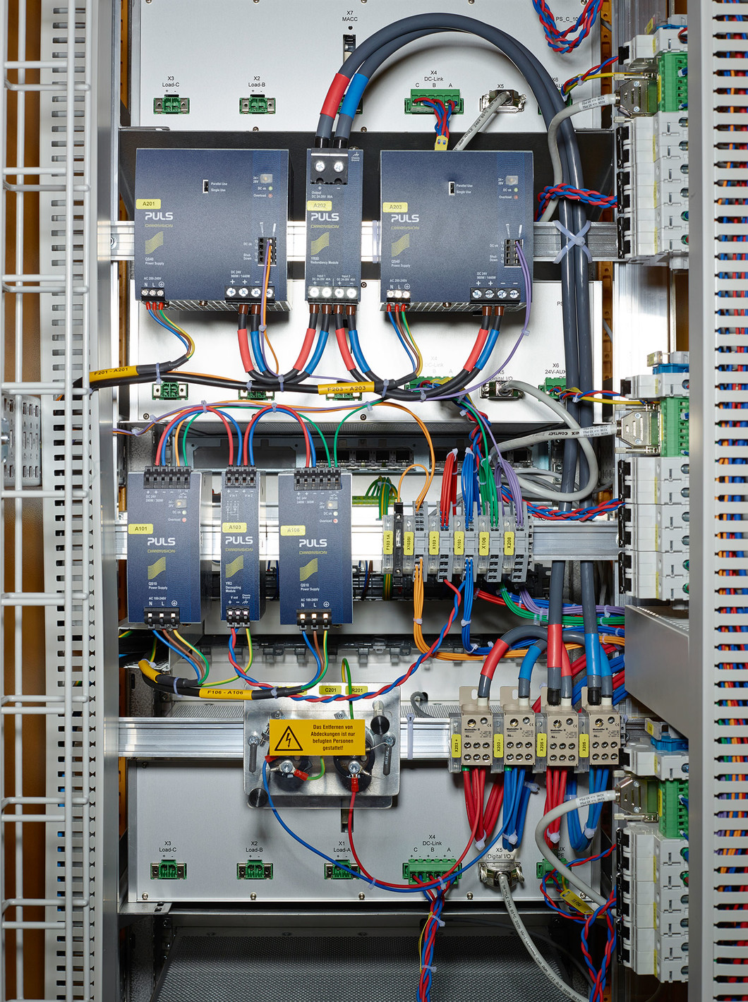 View inside a power supply cabinet from the back. For SwissFEL, up to twenty-one supplies per cabinet are fed by two power modules (top row). If a power module breaks down, the reserves jump in. The same principle is also used for the auxiliary power supply (bottom row). (Photo: Scanderbeg Sauer Photography)