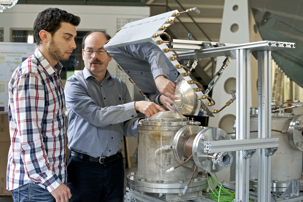 Die Forscher Christian Wieckert und Nikolaos Tzouganatos bei der Arbeit am Solarreaktor. Bild: Paul Scherrer Institut/Markus Fischer.