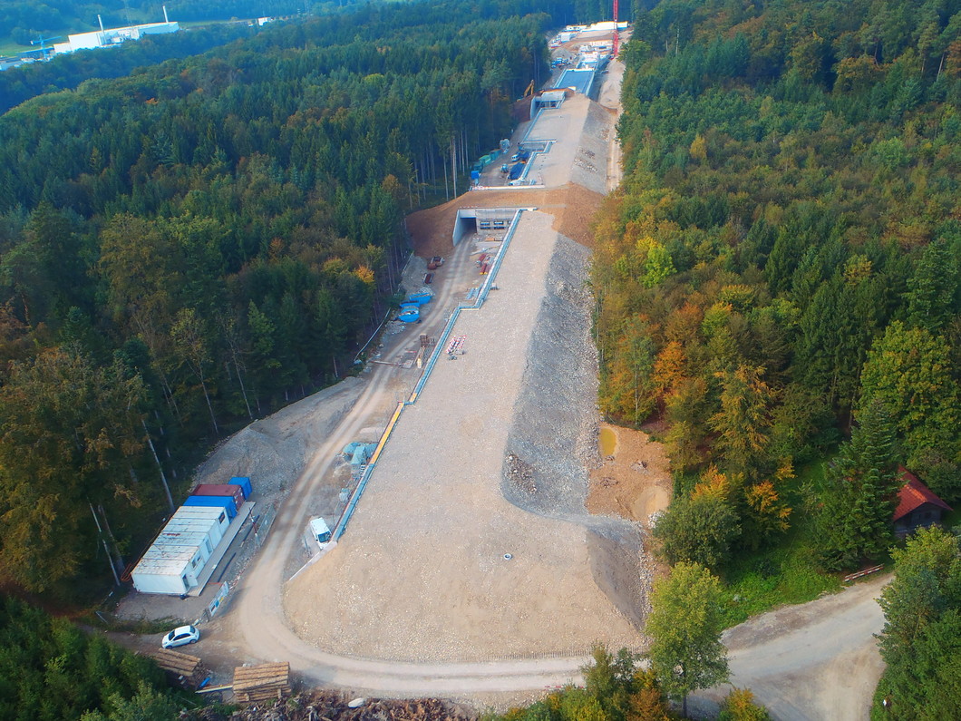 Aerial view of the SwissFEL building taken in September 2014. Work to cover over the facility is currently nearing completion. In the right foreground, two of the already completed amphibian ponds are visible between the mound of earth and the trees. Photo: Heli Partner AG.
