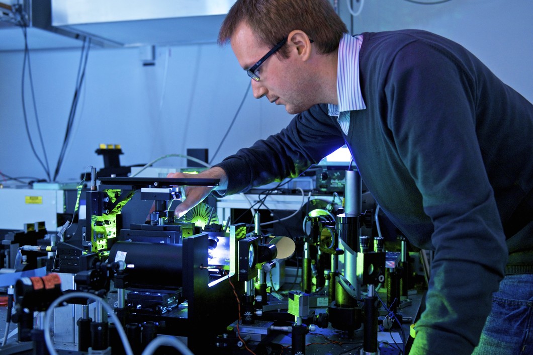 Doctoral Student Richard Geiger investigating the new material in a laser lab at the Paul Scherrer Institute. (Photo: PSI/Markus Fischer)