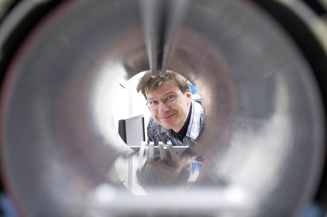 Klaus Kirch, Laborleiter Teilchenphysik am PSI, an einem Testaufbau zur Messung des elektrischen Dipolmoments des Neutrons. Die Forschenden haben eine neue Methode entwickelt, ultrakalte Neutronen zu vermessen. Diese kann womöglich bei der Erklärung helfen, weshalb beim Urknall deutlich mehr Materie als Antimaterie entstand. (Foto: PSI)