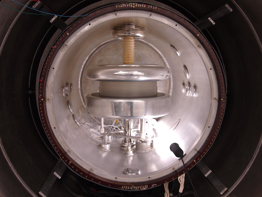 Blick ins Spektrometer, das das elektrische Dipolmoment der Neutronen vermisst. Der Durchmesser des silbernen Aluminiumtanks beträgt einen Meter. Aussen herum befindet sich im dunklen Bereich ein Magnetschild, dass das Erdmagnetfeld um den Faktor 10'000 abschwächt. (Foto: PSI/Zema Chowdhuri)