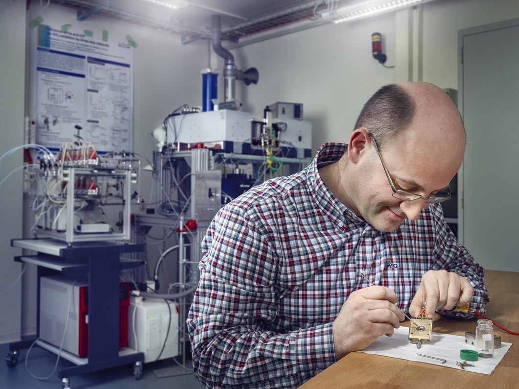Davide Ferri monte un échantillon de catalyseur dans la chambre de mesure. Ensuite, l’échantillon est fixé dans l’instrument que l’on aperçoit à l’arrière-plan, où il sera étudié à l’aide de la lumière synchrotron. (Photo: Scanderbeg Sauer Photography)