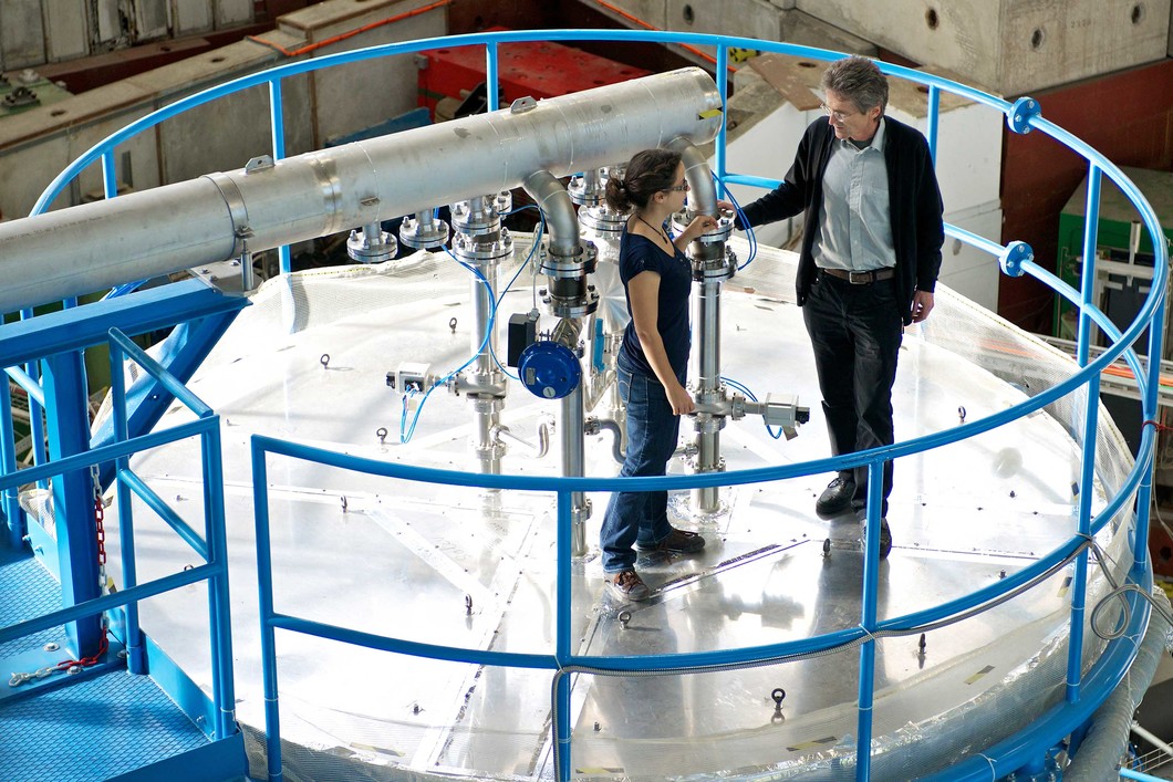 Die PSI-Forschenden Jasmin Tröstl und Urs Baltensperger auf der CLOUD-Kammer am CERN, in der sie die Entstehung von Aerosolen in der Atmosphäre erforscht haben. (Foto: Paul Scherrer Institut/Markus Fischer)