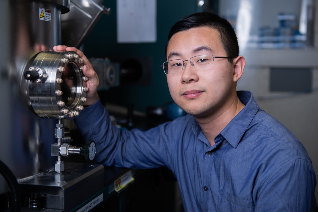Zhaochu Luo, Hauptautor der Studie, vor einer sogenannten Sputter-Depositions-Apparatur. In der Vorrichtung werden die Schichten aus Platin, Kobalt und Aluminiumoxid erzeugt. Jede Schicht ist nur wenige Nanometer dünn. (Foto: Paul Scherrer Institut/Mahir Dzambegovic)