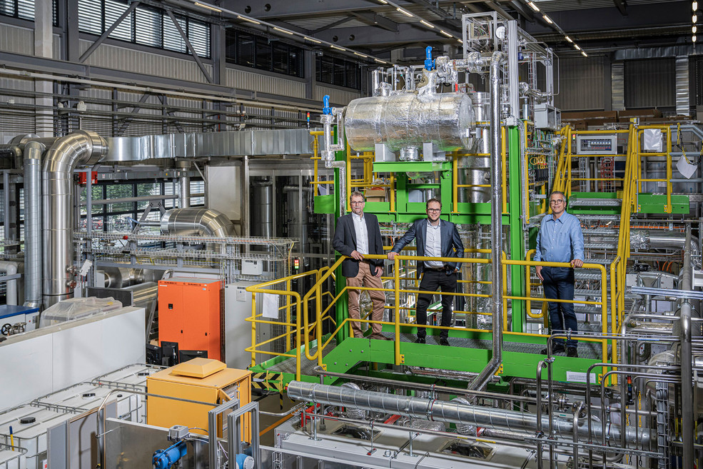 Andreas Aeschimann and Luca Schmidlin from AlphaSYNT, and Tilman Schildhauer from PSI (left to right) in front of the GanyMeth pilot plant at PSI. 