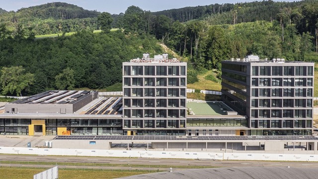 Das Technologietransferzentrum Swiss PIC wird in den Park Innovaare einziehen und damit in die unmittelbare Nachbarschaft des PSI: Das runde Dach im Bildvordergrund gehört zur Synchrotron Lichtquelle Schweiz SLS, die sich auf dem PSI-Gelände West befindet, dahinter ist ein Teil des Gebäudekomplexes Park Innovaare zu sehen.