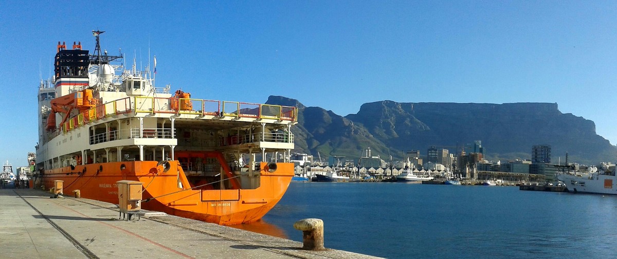 Research vessel Akademik Tryoshnikov in the Cape Town harbor with the Table Mountain in the background, ready to depart