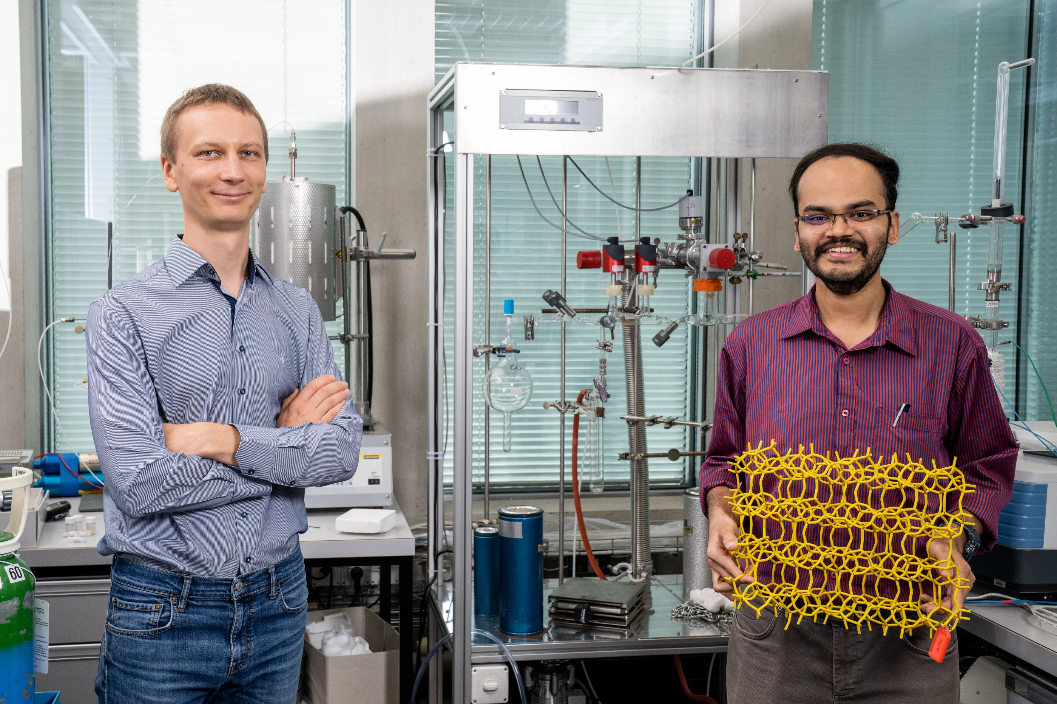 Vitaly Sushkevich (à gauche) et Manoj Ravi dans un laboratoire du PSI, avec une maquette d’un squelette de zéolithe.