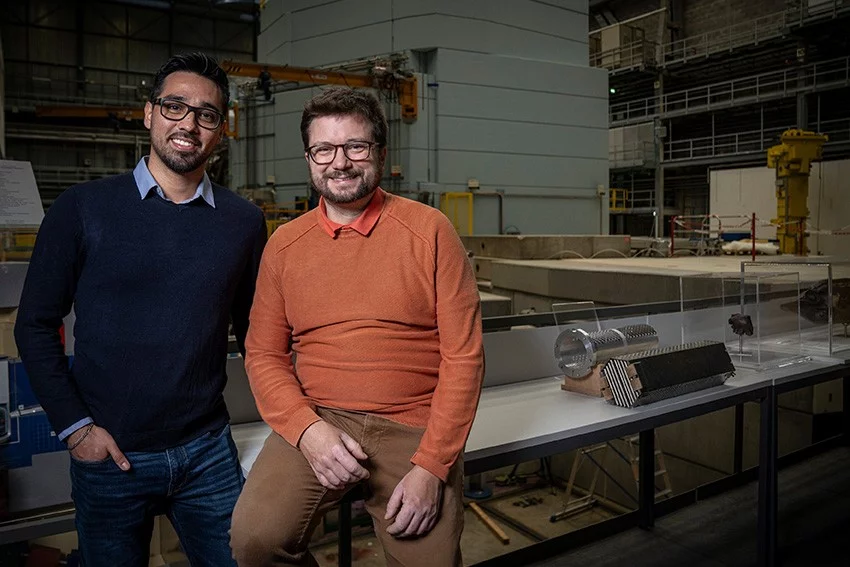 Eric Ricardo Carreon Ruiz (à gauche) et Pierre Boillat devant une partie de la Source suisse de neutrons de spallation SINQ du PSI.