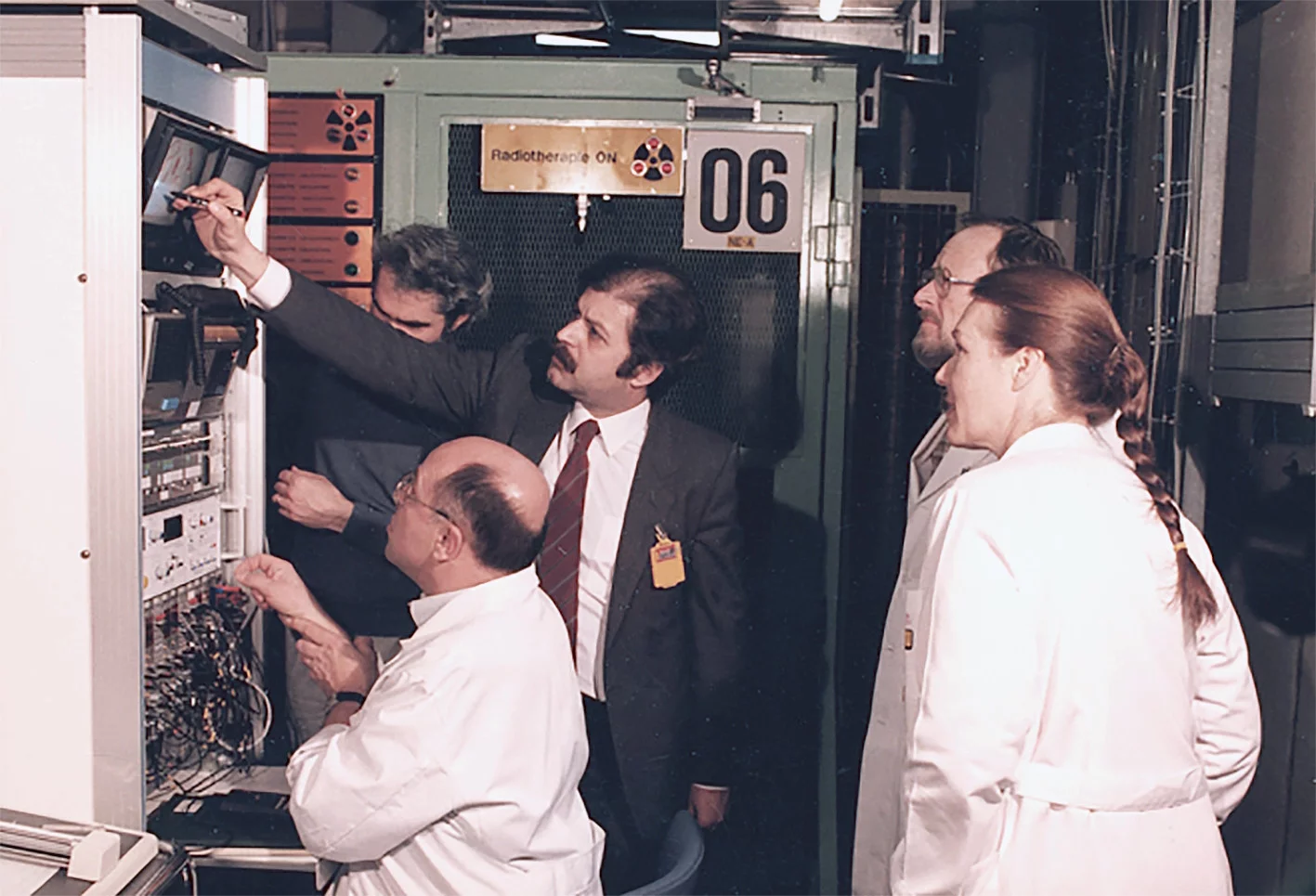 L’équipe OPTIS dans la salle de contrôle pendant le traitement du premier patient en mars 1984. Les deux initiateurs du projets sont présents: Charles Perret (assis) et Leonidas Zografos (debout, troisième depuis la droite).