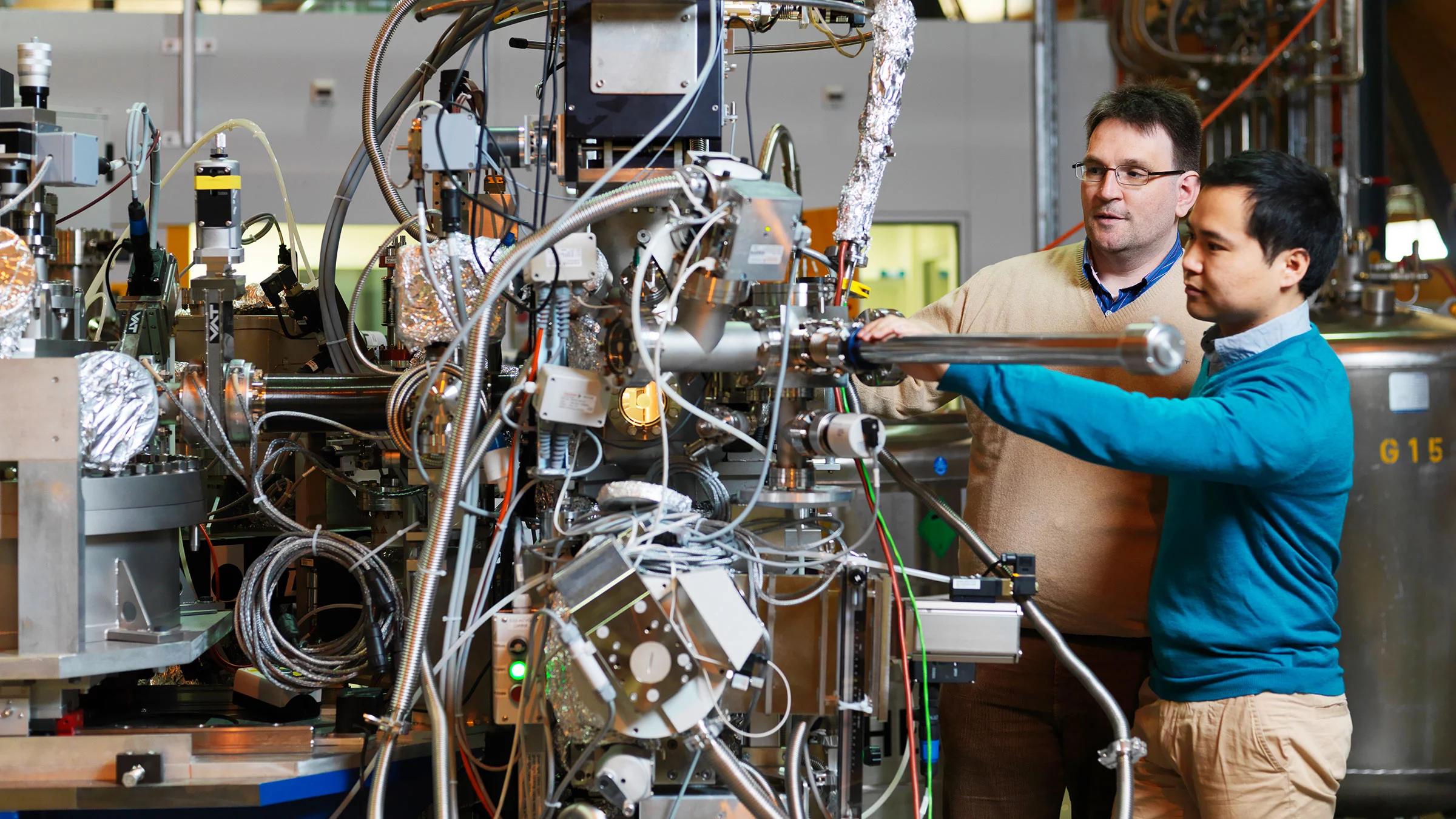PSI researchers inserting a sample into a measuring apparatus at the SLS. Here, X-rays are used for investigating materials with very high precision.
