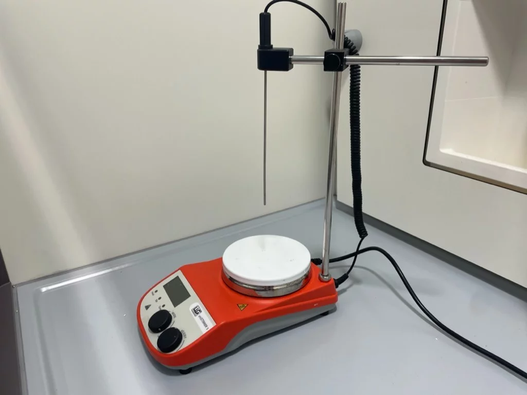 Orange stirring plate with long metal temperature probe and power cords