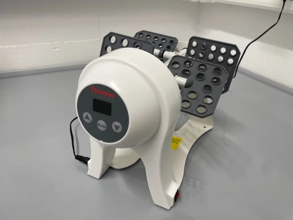 Small white plastic electronic device with grey paddles with holes in for small tubes 