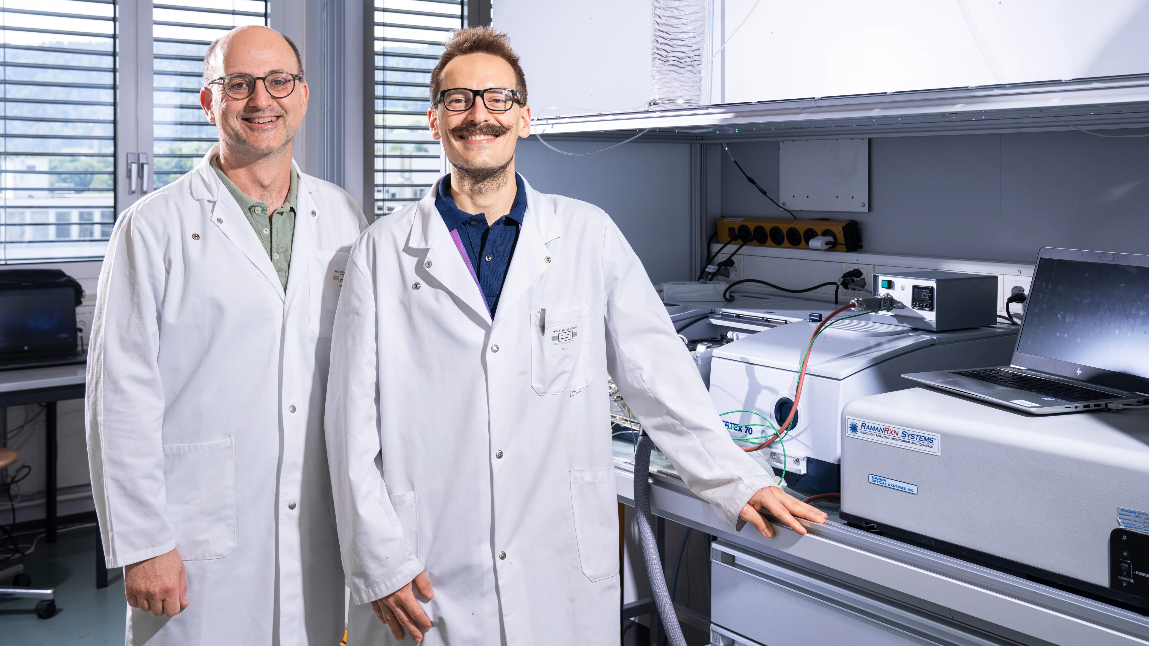 Davide Ferri (links) und Filippo Buttignol in ihrem Labor, wo sie die Funktionsweise von Zeolith-Katalysatoren mittels Infrarotspektroskopie untersucht haben.  