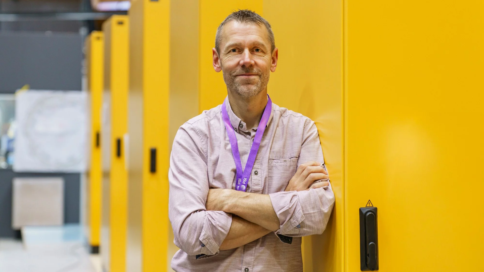 Emanuel Hüsler de la section installations électriques du Centre des services corporatifs est adossé contre un des racks électroniques jaunes. Les racks déterminent le nombre de câbles entrant et sortant de l’anneau de stockage des électrons de la SLS. 