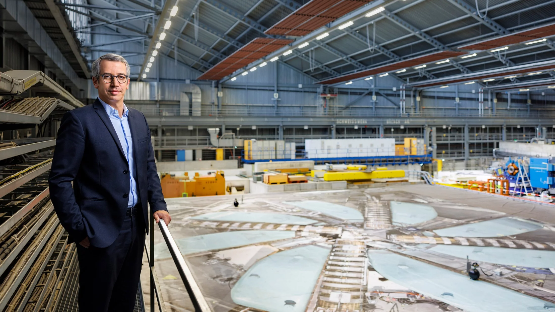 PSI Director Christian Rüegg at the cover of the cyclotron, which represents the third acceleration stage for the proton beam at PSI, which is unique worldwide. 