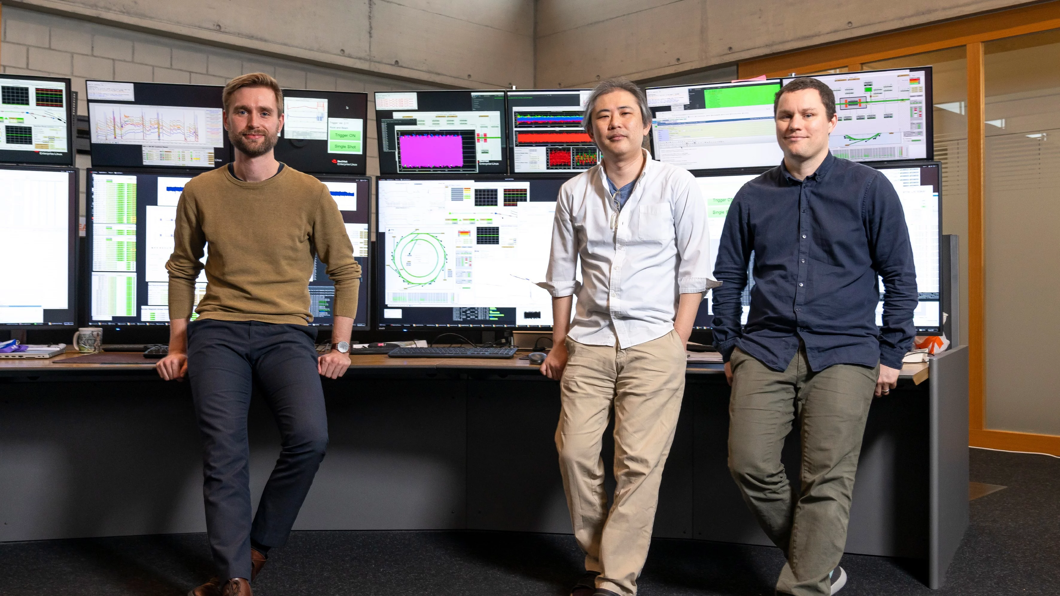 Jonas Kallestrup, Masamitsu Aiba und Felix Armborst (von links) im Kontrollraum des PSI. Sie sind Teil des Commissioning-Teams, das im Zuge des Upgrade-Projekts SLS 2.0 nun die Elektronen zurück in den Elektronenspeicherring des Synchrotrons gebracht hat. 