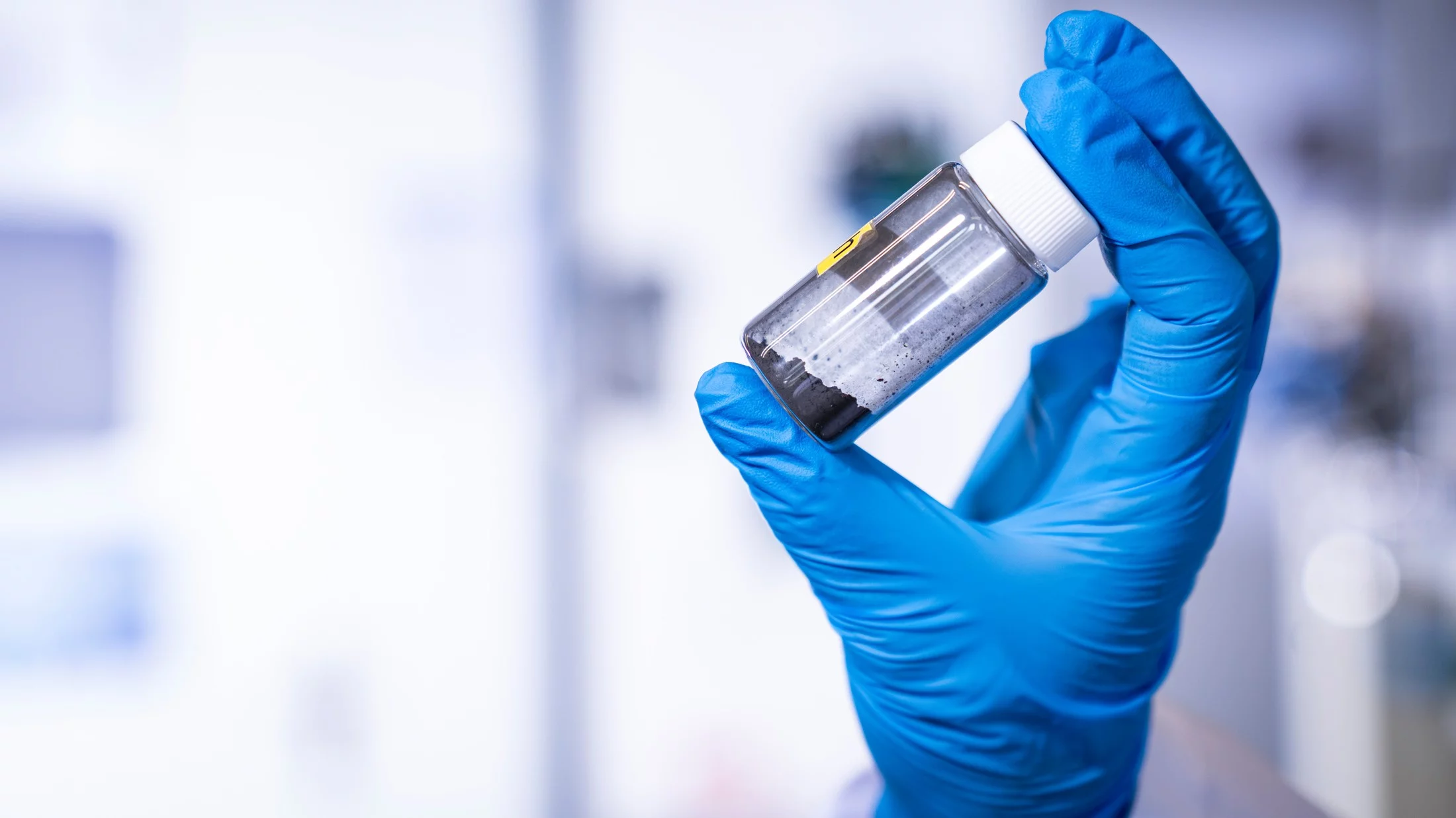 Im Fokus: ein Glasfläschchen mit Katalysatorpulver auf Kobaltbasis – aufgenommen im Labor des Paul Scherrer Instituts PSI. Forschende des Zentrums für Energie- und Umweltwissenschaften haben gezeigt, warum dieser Katalysator bei der Herstellung von Wasserstoff im alkalischen Milieu besonders effizient wirkt. 