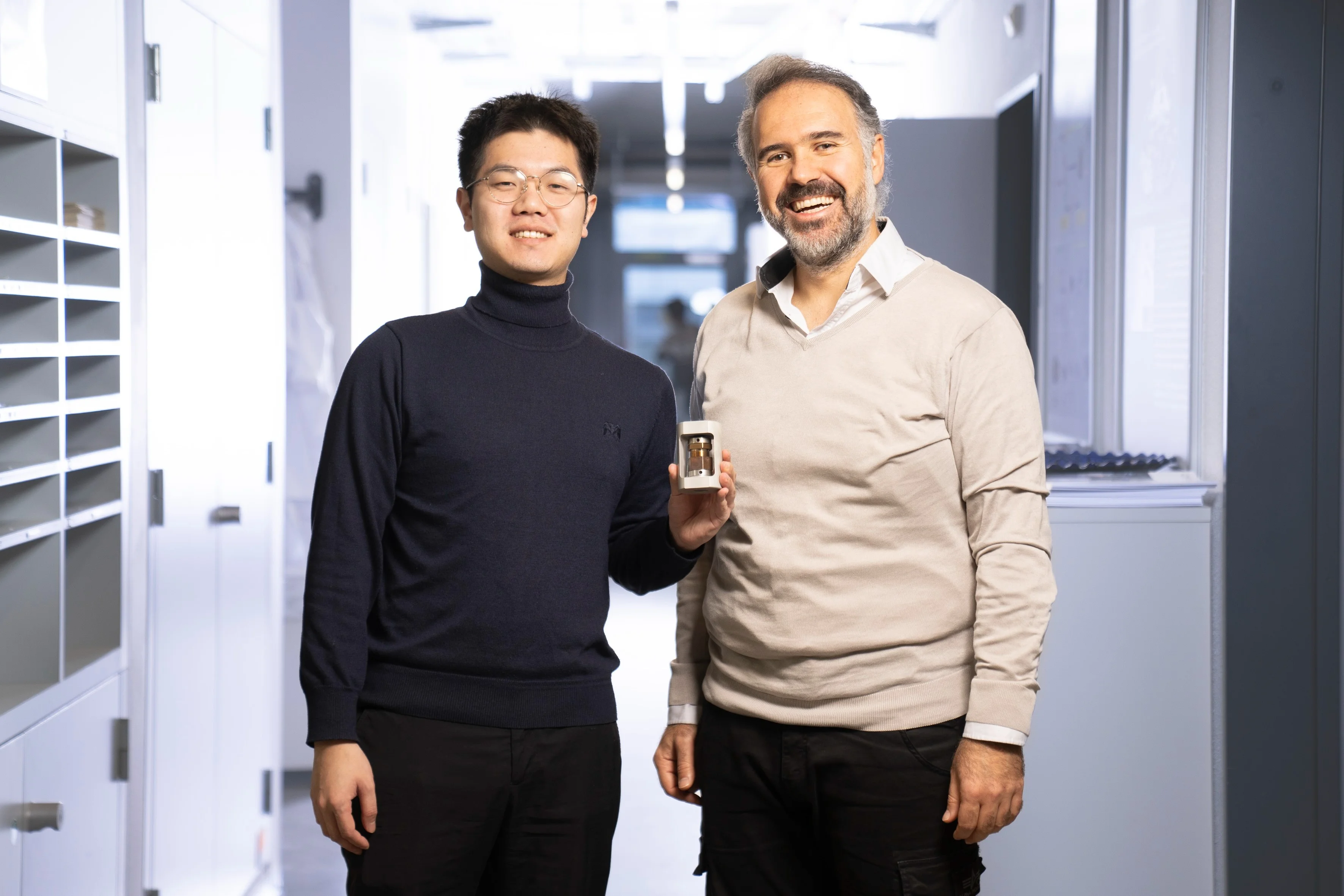 Jinsong Zhang und Mario El Kazzi (von links nach rechts) mit einer Testzelle der am Paul Scherrer Institut PSI entwickelten Festkörperbatterie. Die beiden Forscher haben ein Verfahren entwickelt, das mildes Sintern mit einer ultradünnen Lithiumfluorid-Beschichtung kombiniert und so besonders stabile Festkörperelektrolyte ermöglicht. 