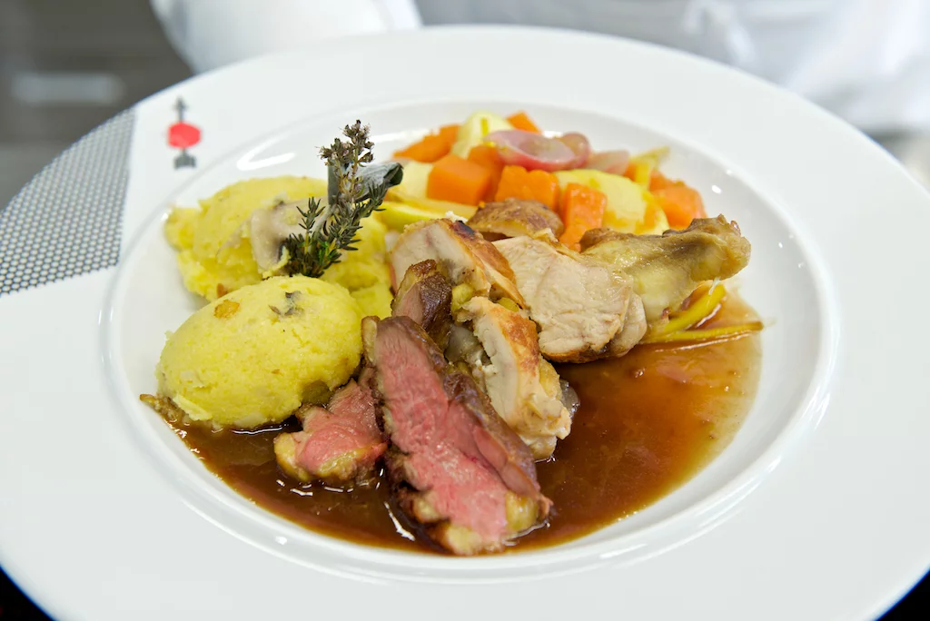 Gefüllte Maispoulardenbrust und gebratene Entenbrust mit Pilzpolenta