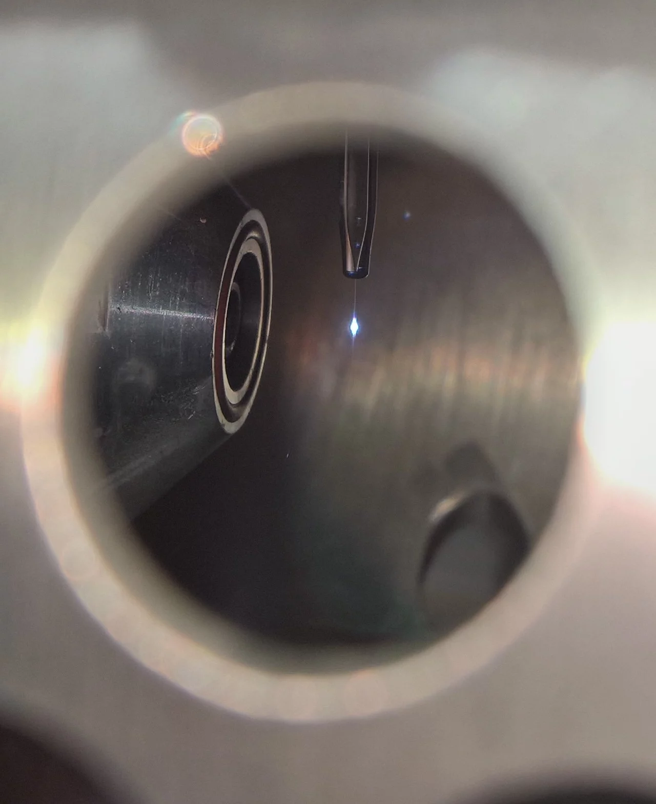 Visible light hitting the liquid filament in front of the analyzer cone.