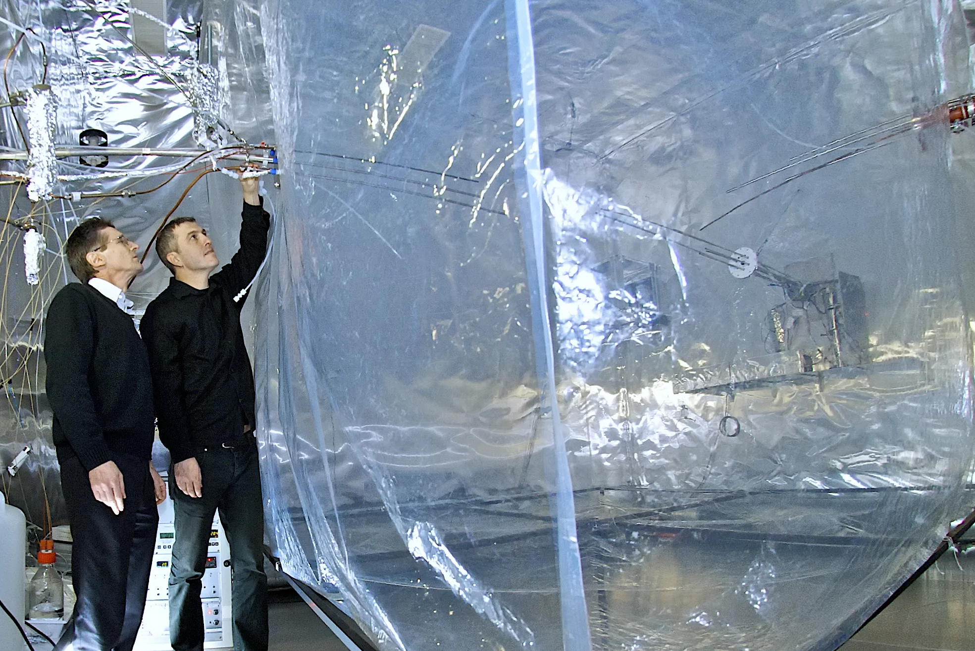 PSI-Forscher Urs Baltensperger (links) und André Prévôt neben der Smogkammer des Instituts, in der Vorgänge in der Atmosphäre simuliert werden.