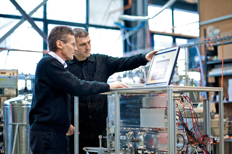 PSI scientists Urs Baltensperger (left) and André Prévôt with the mass spectrometer that made new insights into the creation of particulates in the atmosphere possible.