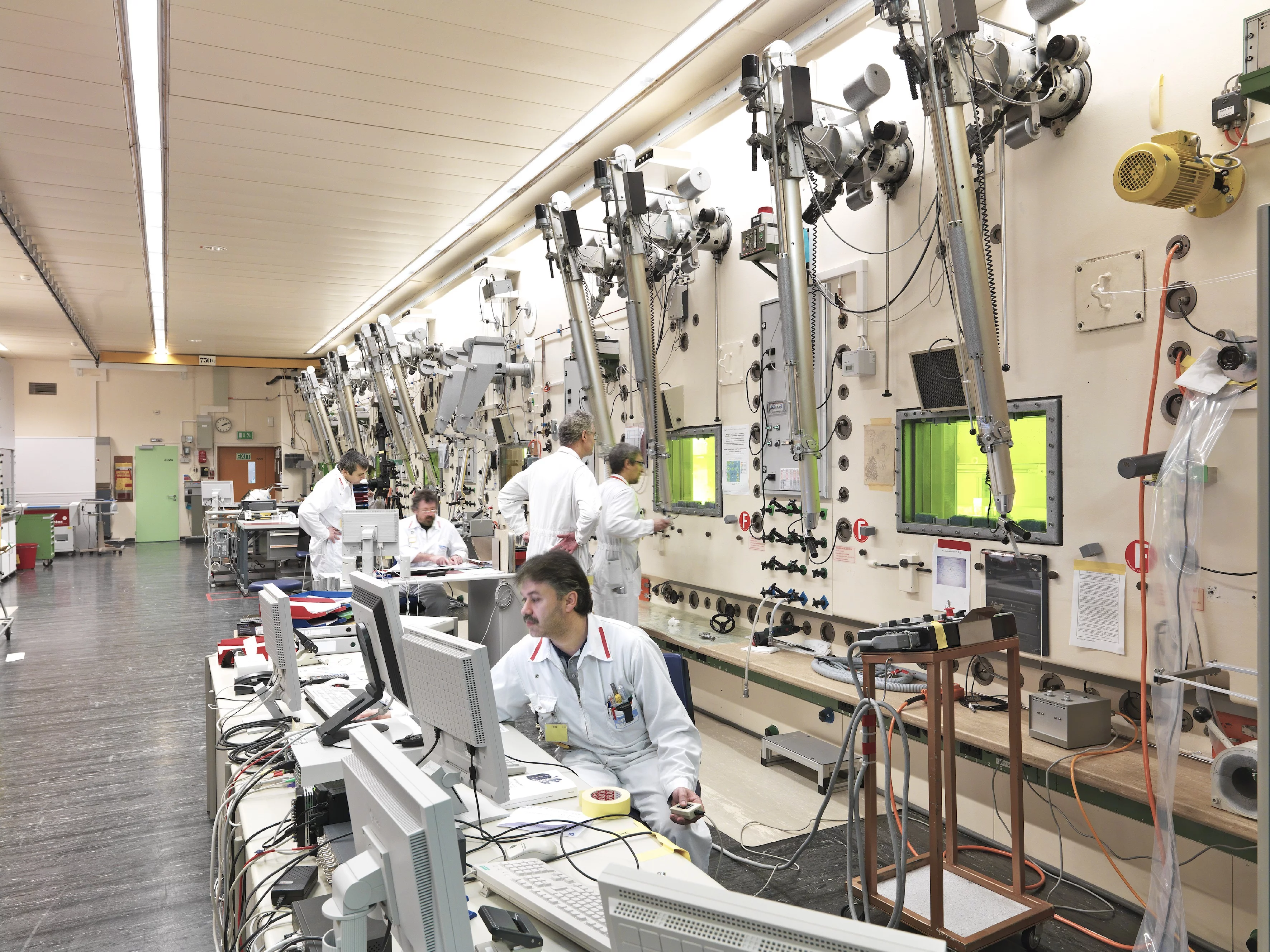 Des échantillons radioactifs sont analysés au Laboratoire chaud. Des mesures de sécurité strictes encadrent la manipulation des matériaux. Les collaborateurs utilisent des bras de préhension et travaillent protégés par d'épaisses fenêtres en verre au plomb. (Photo: Scanderbeg Sauer Photography)