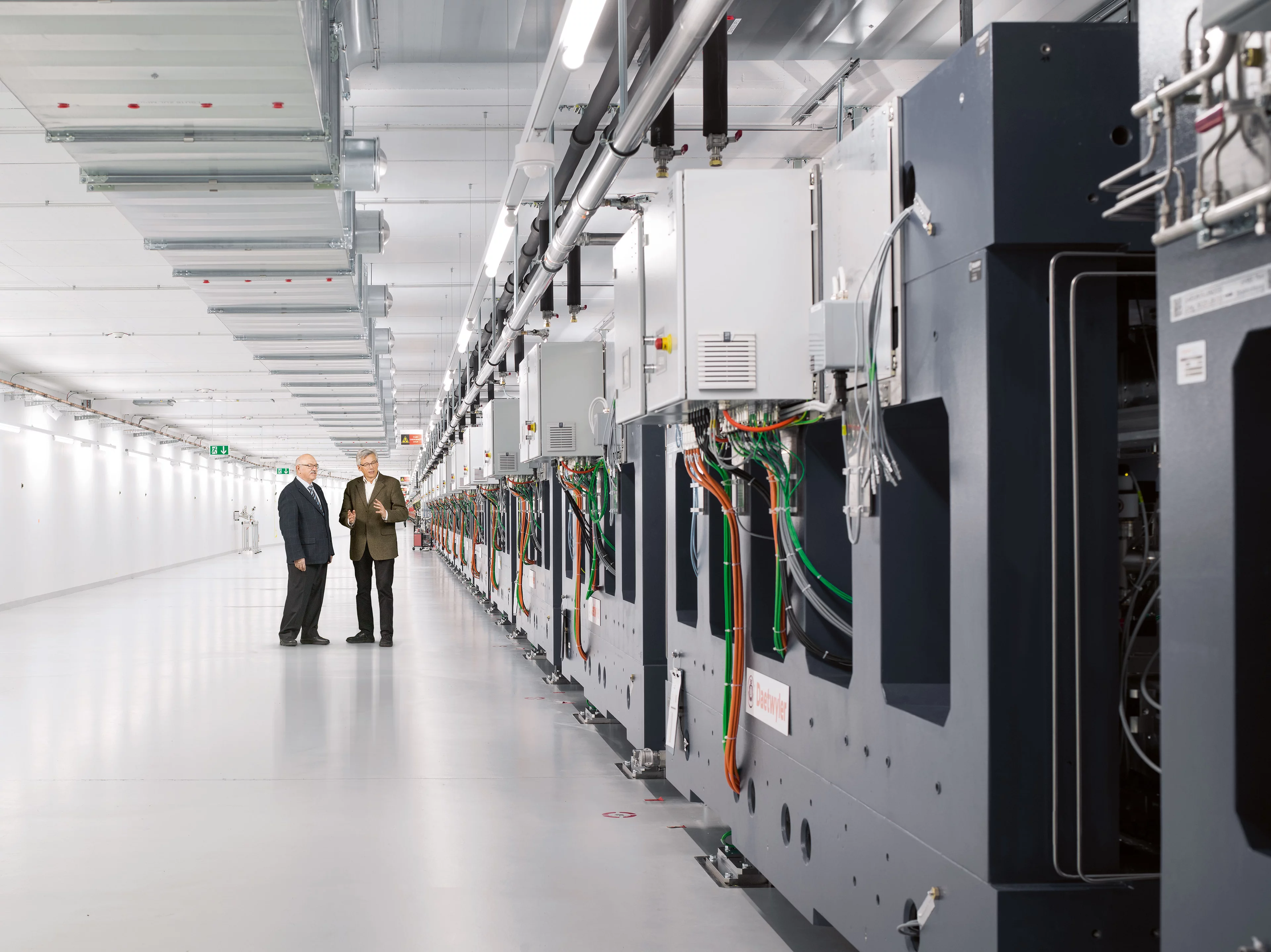 Au SwissFEL: Peter Daetwyler (à gauche), président du Conseil d’administration de Daetwyler AG, et Hans Braun, chef du projet SwissFEL au PSI, inspectent encore une fois les onduleurs définitivement installés. (Photo: Scanderbeg Sauer Photography)