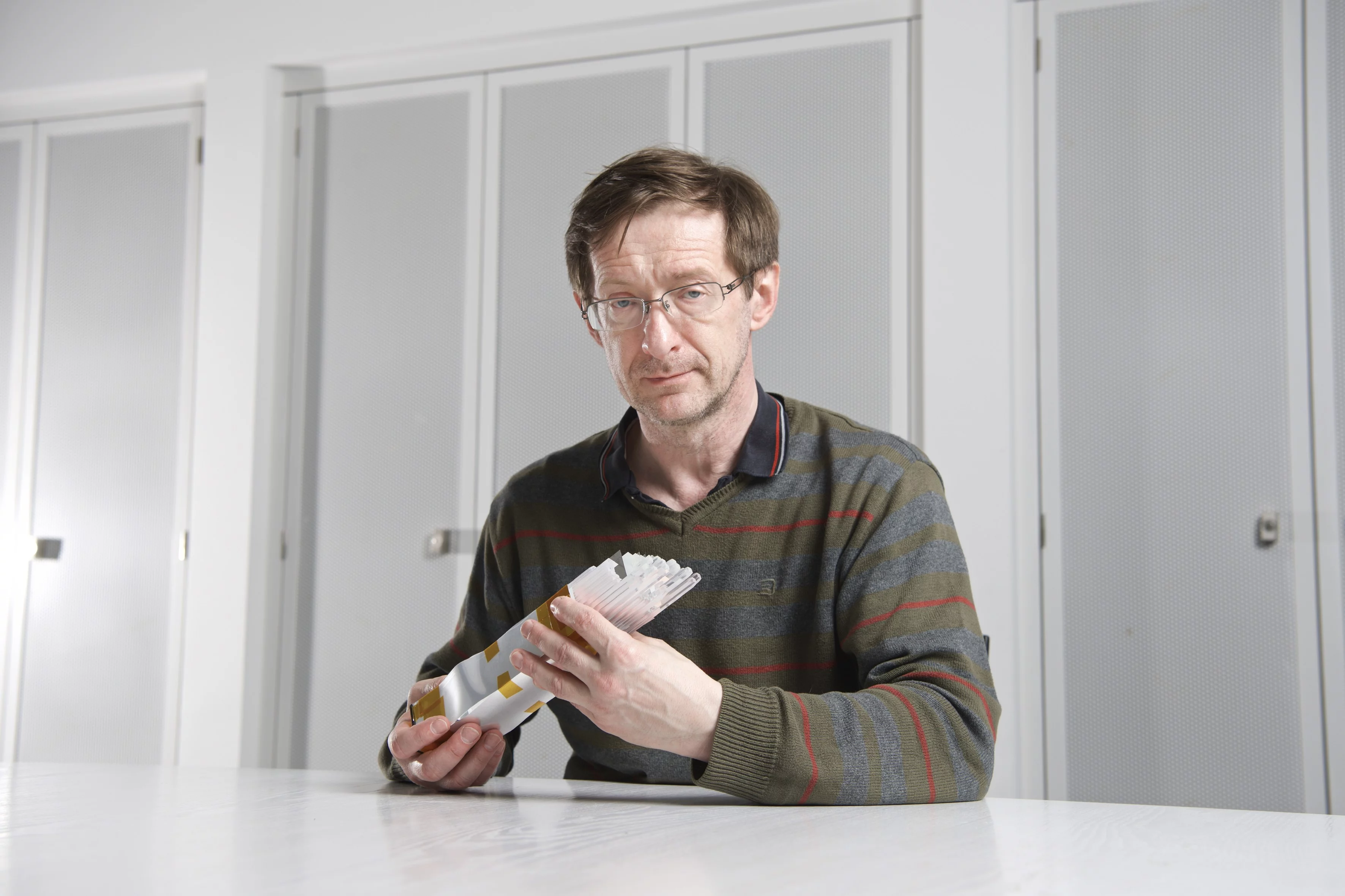 Wojciech Hajdas avec des barres scintillatrices, qui ont aussi été montées sous cette forme dans le détecteur POLAR. (Photo: Institut Paul Scherrer/Markus Fischer)