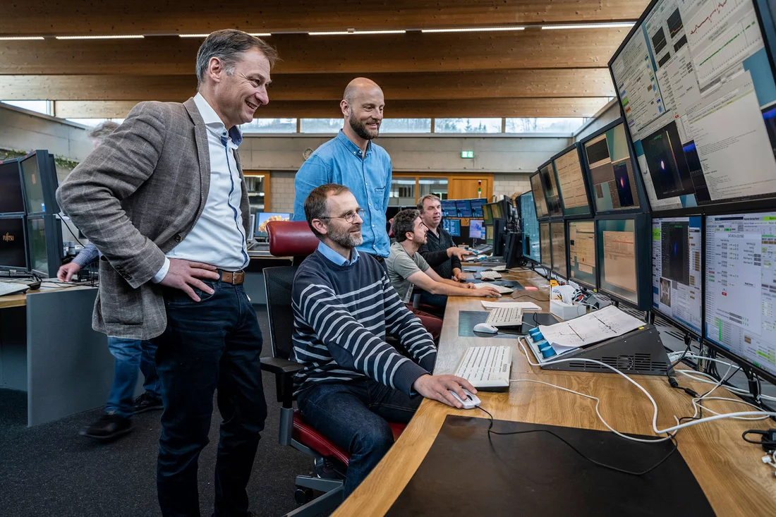 Romain Ganter et Luc Patthey (debout) dans la salle de contrôle du PSI avec Didier Voulot, opérateur d’Athos.