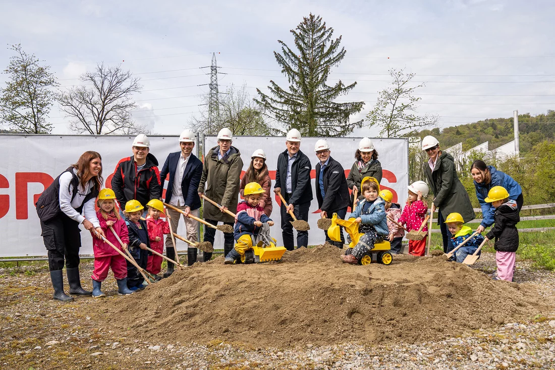 Smiling for the photo: The adults include PSI’s Director Christian Rüegg (fourth adult from the left), the Construction Project Manager Tuba Demirhan (to the right of Rüegg) and the Head of the Day-Care Centre Simone Brunner (second adult from the right).