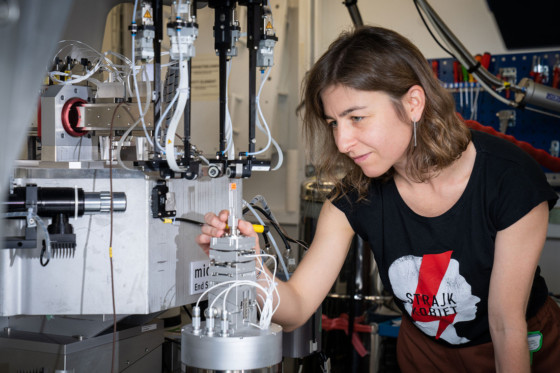 Malgorzata Makowska, scientist at the MicroXAS beamline of the SLS, carefully positions a standard material for setup calibration on the sample manipulator in front of the X-ray beam.  