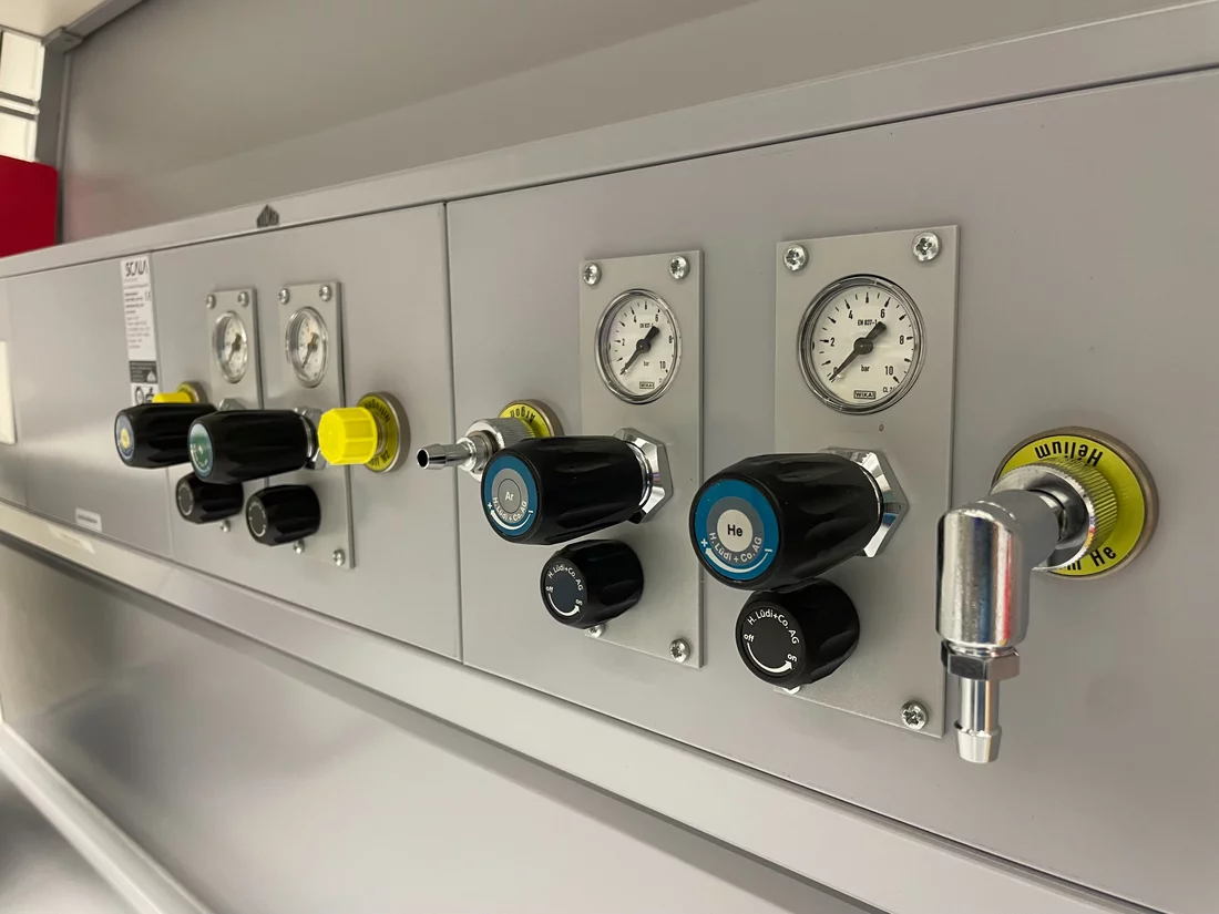 Black knobs and gauges on a grey wall 