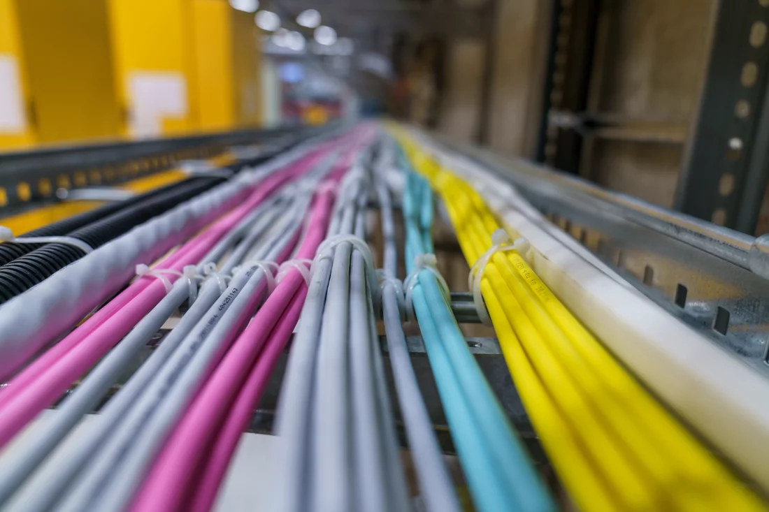 Les câbles se trouvent en partie dans des glissières telles que celle-ci et suivent de longues trajectoires autour du synchrotron. Et non, les couleurs n’ont pas été choisies pour correspondre au nouveau design du PSI mais servent à distinguer les éléments: les câbles à fibre optique multimode sont roses, leurs pendants singlemode sont jaunes. 