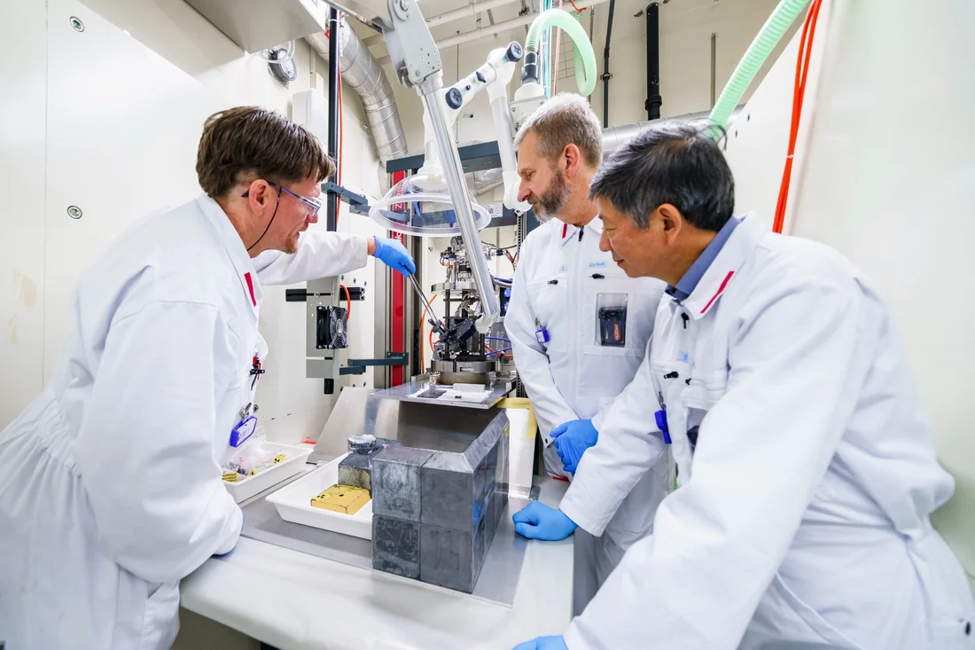 Roger Brun, Manuel Pouchon, and Yong Dai setting up tensile testing of irradiated STIP specimens. 