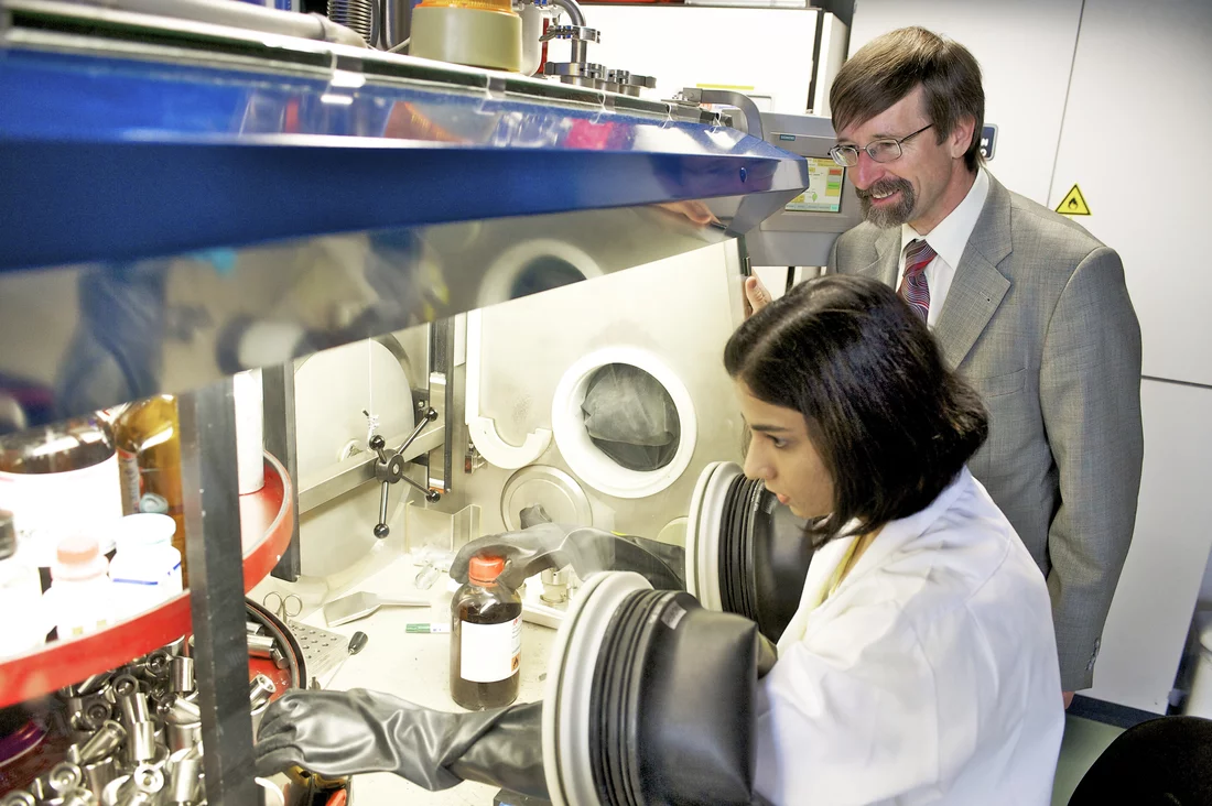 Die Doktorandin Pallavi Verma und Professor Petr Novák, Leiter der Sektion Elektrochemische Speicher am Paul Scherrer Institut, im Labor.  Hier werden elektrochemische Testzellen zusammengebaut, an denen die Batterieleistung untersucht werden kann. Das geschieht in einer Handschuhbox, weil Materialien für Lithium-Batterien nicht mit Luft in Kontakt kommen dürfen und daher in einer Atmosphäre aus Argon bearbeitet werden.  (Foto: PSI/F. Reiser)