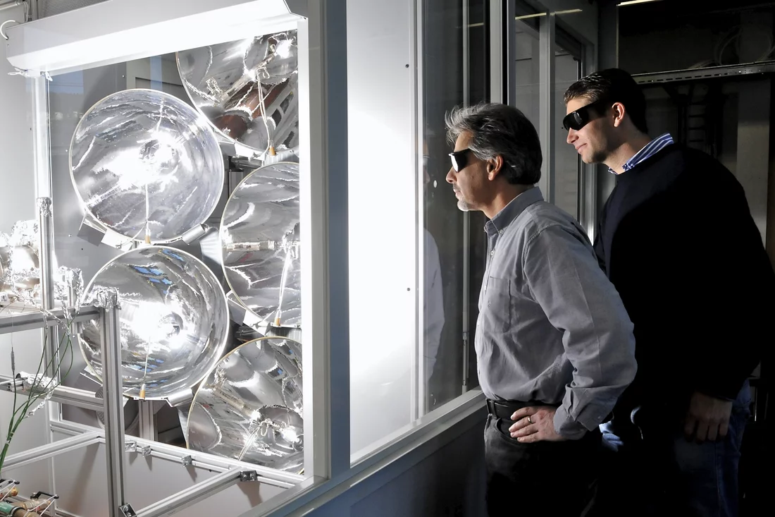 Professor Aldo Steinfeld  und Doktorand Philipp Furler verfolgen ein Experiment mit ihrem solaren thermochemischen Reaktor zur Treibstoffgewinnung aus Wasser und CO2 am Hochfluss-Solarsimulator der ETH Zürich. Die Experimente, auf denen die dargestellten Ergebnisse beruhen, wurden am Hochfluss-Solarsimulator des Paul Scherrer Instituts durchgeführt. (Bild: Peter Rüegg / ETH Zürich)